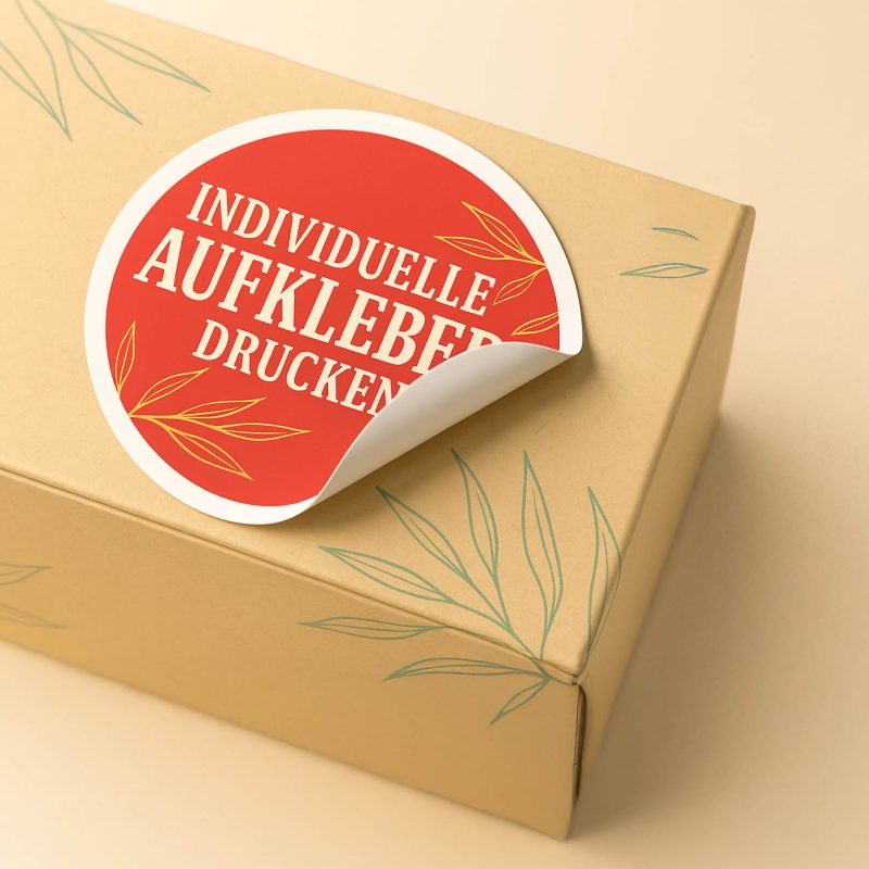 Runder Aufkleber mit rotem Design und weißer Schrift auf Verpackungskarton, individuell gedruckt von alenio Werbung in Berlin